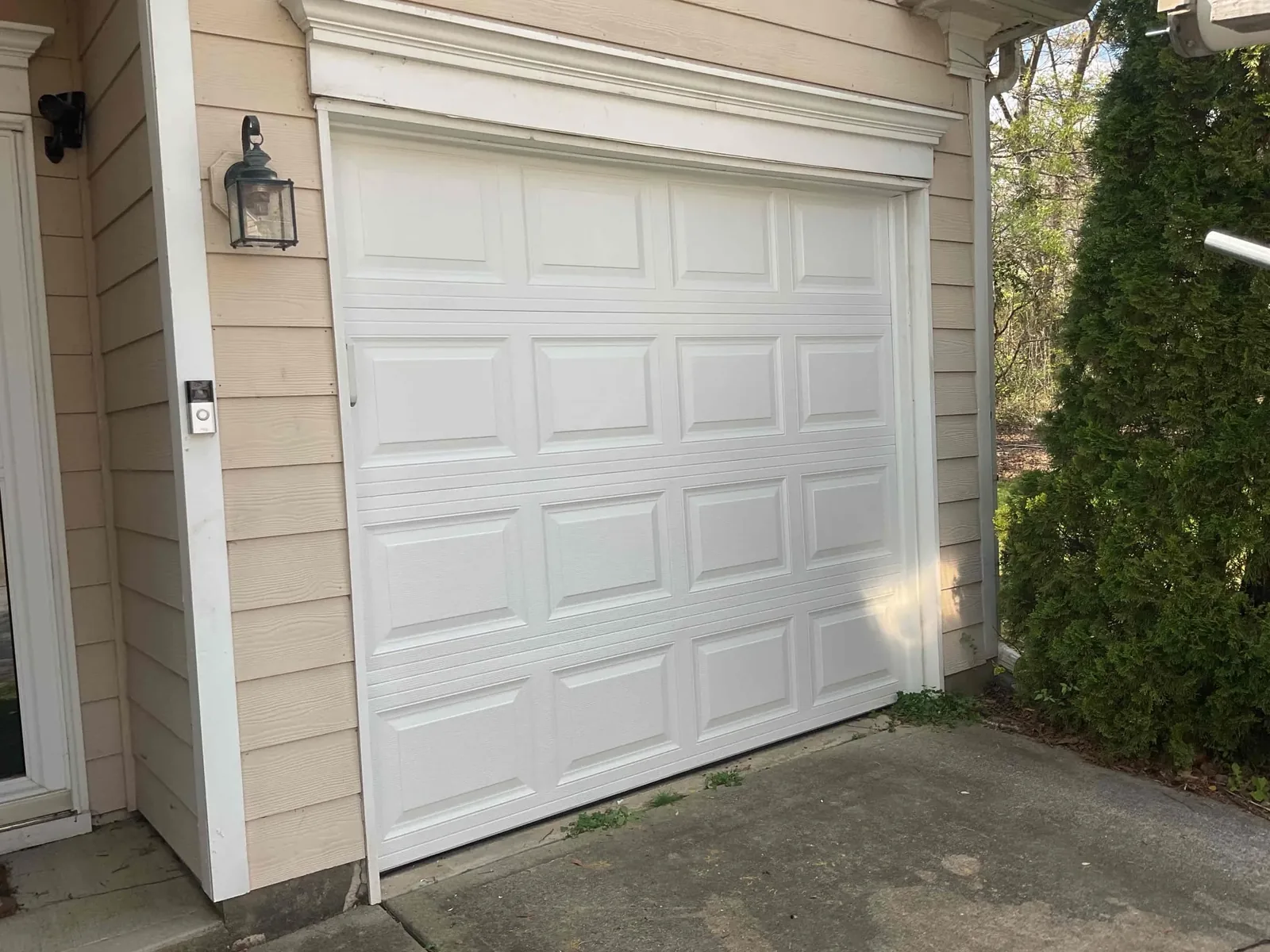 Modern white garage door framed by dark trim on a contemporary home