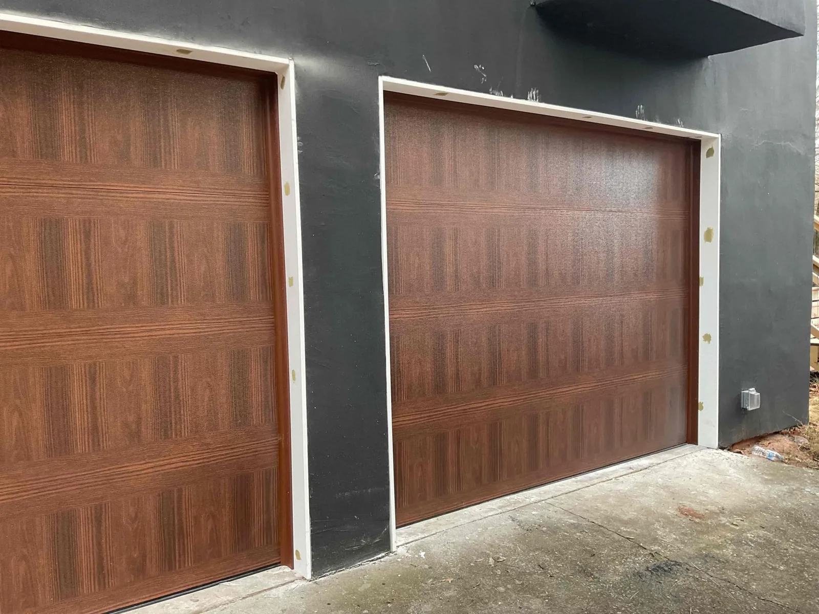 Wood-look garage doors installed on a modern home